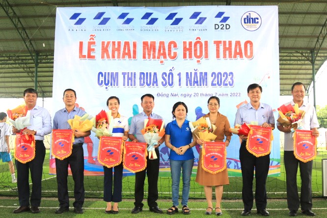 Mrs. Nguyen Thi Hanh - CEO of Sonadezi Giang Dien Shareholding Company (middle) presents flowers and souvenir flags to representatives of companies in Cluster 01