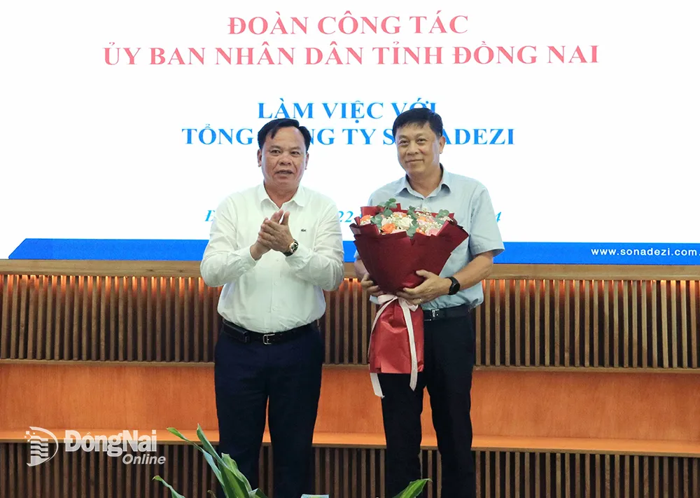 Quyền Chủ tịch UBND tỉnh Võ Tấn Đức tặng hoa chúc mừng ông Trương Đình Hiệp được bầu giữ chức Chủ tịch HĐQT Tổng công ty Sonadezi. Ảnh: V.Thế